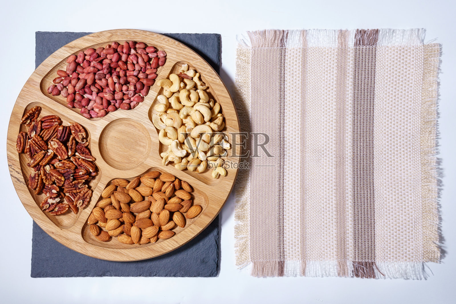 石头桌上的坚果。顶部视图与空间复制。腰果，山核桃，花生，杏仁照片摄影图片