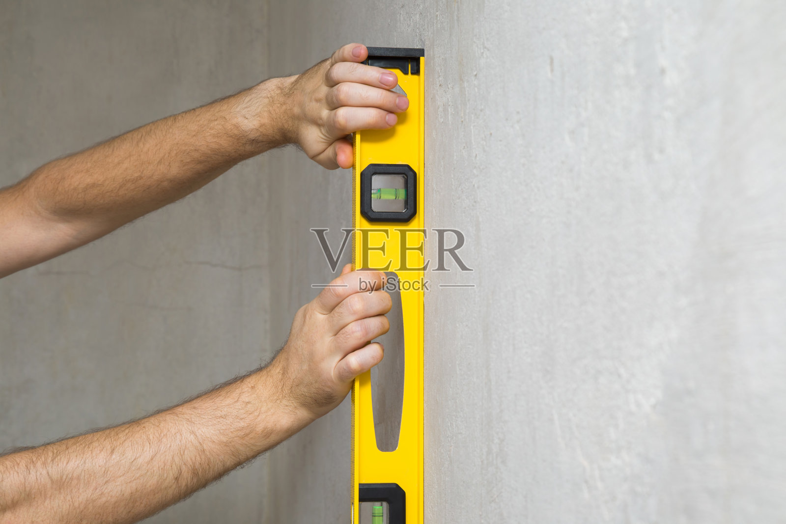 维修前，工人用手测量混凝土墙面。精密的工作。特写镜头。照片摄影图片