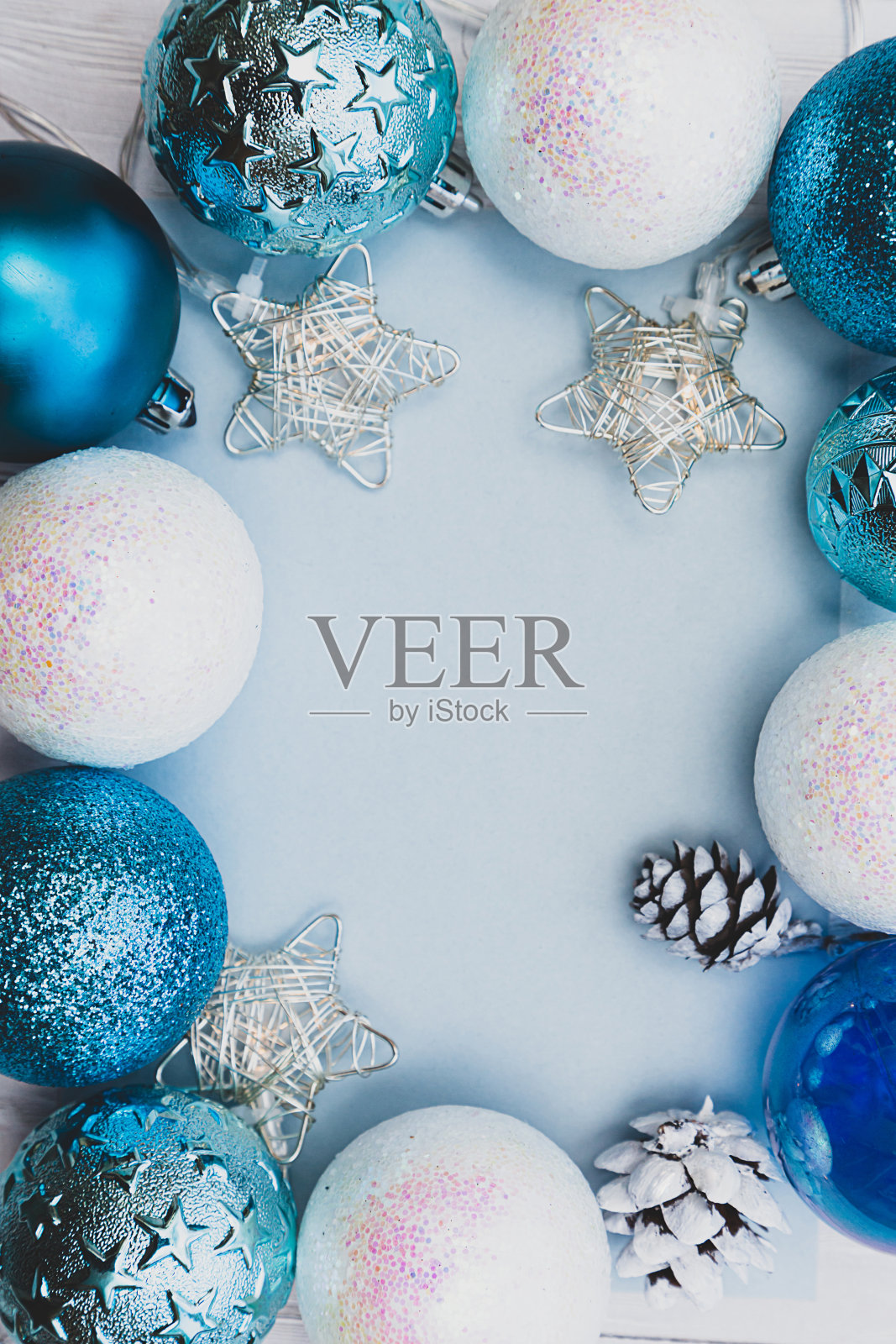 框架是由圣诞蓝白球，花环星星和白色圆锥。节日作文与文字的地方照片摄影图片