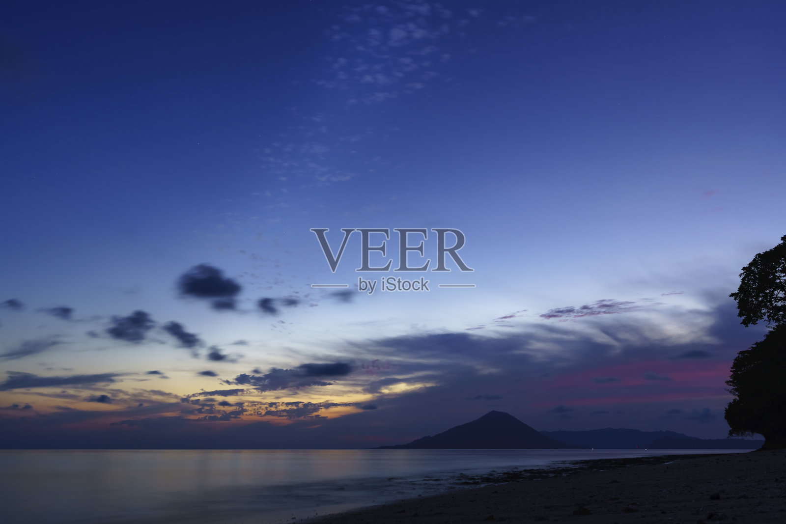 从印尼东部马鲁古班达群岛的艾岛营地看到的Gunung Api火山美丽的早晨天空照片摄影图片