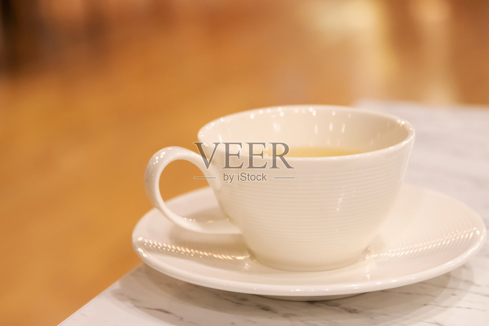 在舒适的咖啡馆和餐厅的桌子上，一杯茶和模糊的背景。照片摄影图片