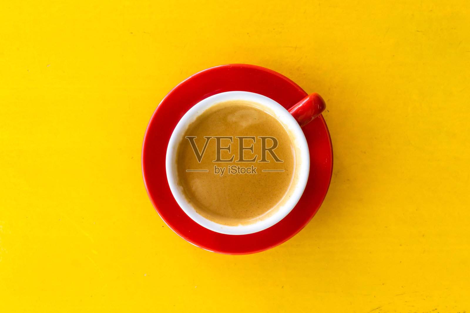 一张黄色桌子上放着红色咖啡杯的照片照片摄影图片