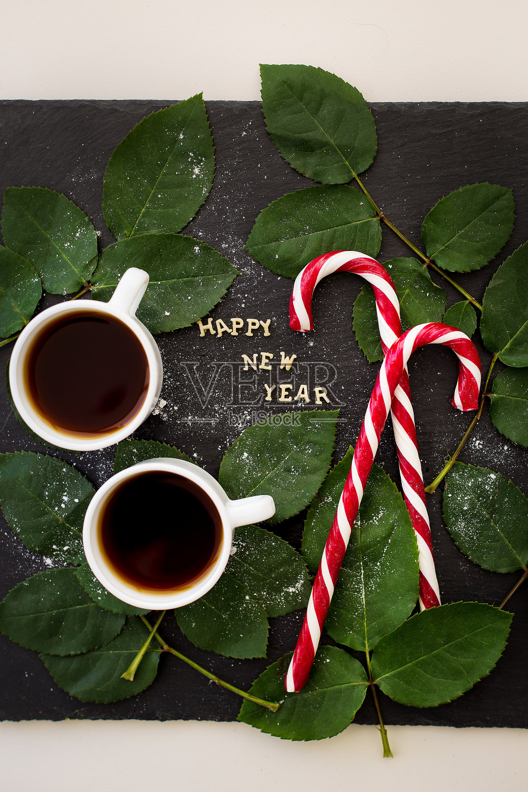 在一块用树叶和红色糖果装饰的黑板上写新年的碑文照片摄影图片