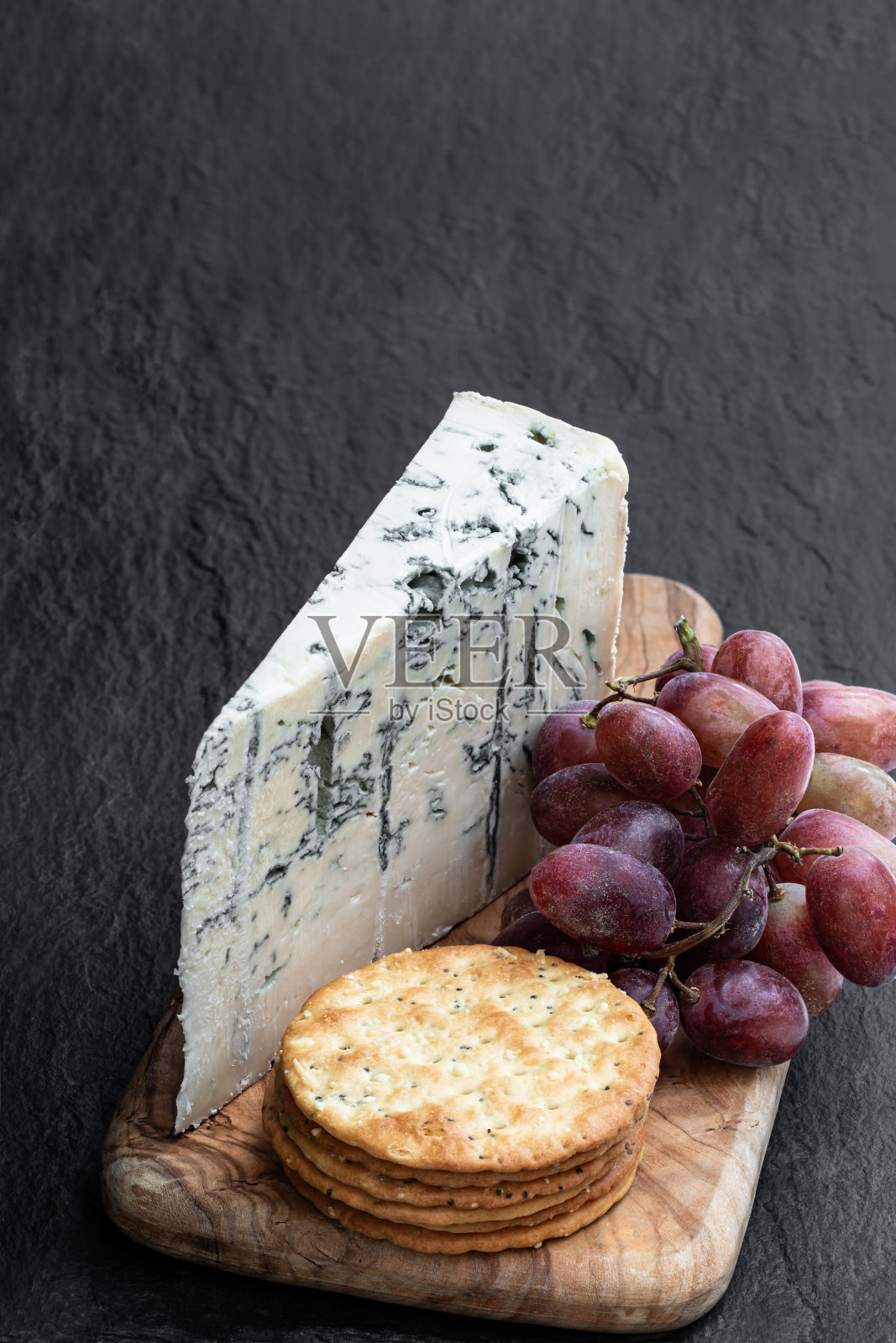 戈贡佐拉奶酪，葡萄和饼干在黑石头的背景照片摄影图片