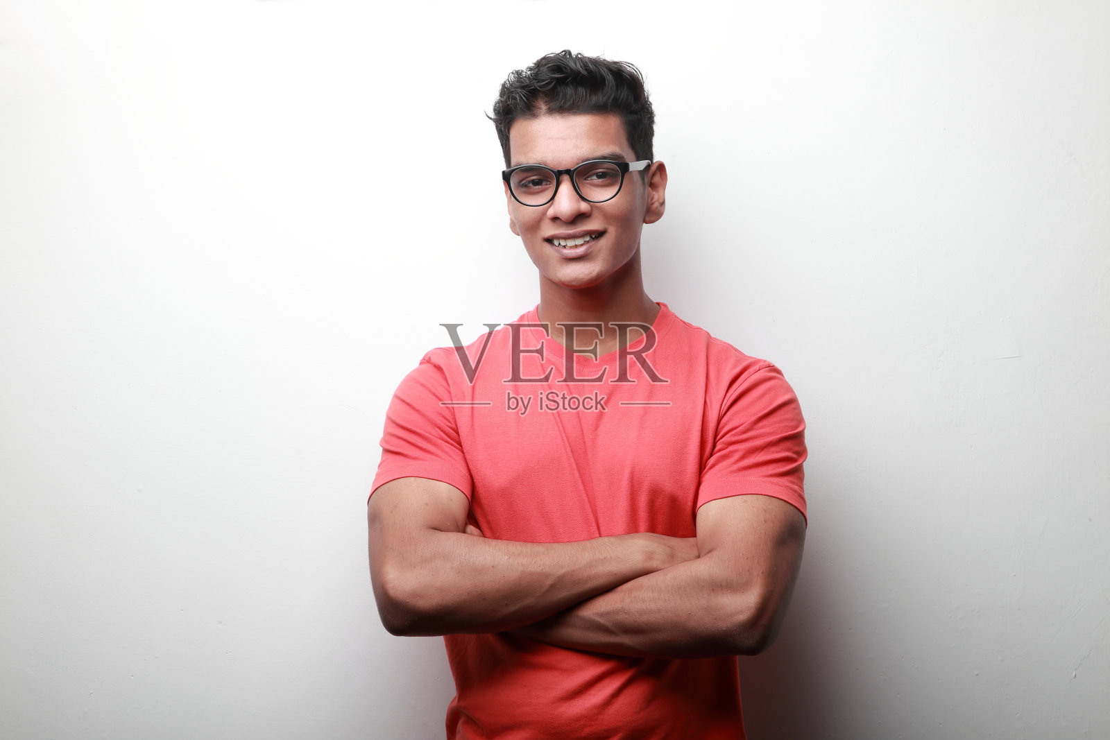 自信微笑的印度裔年轻人双手交叉照片摄影图片