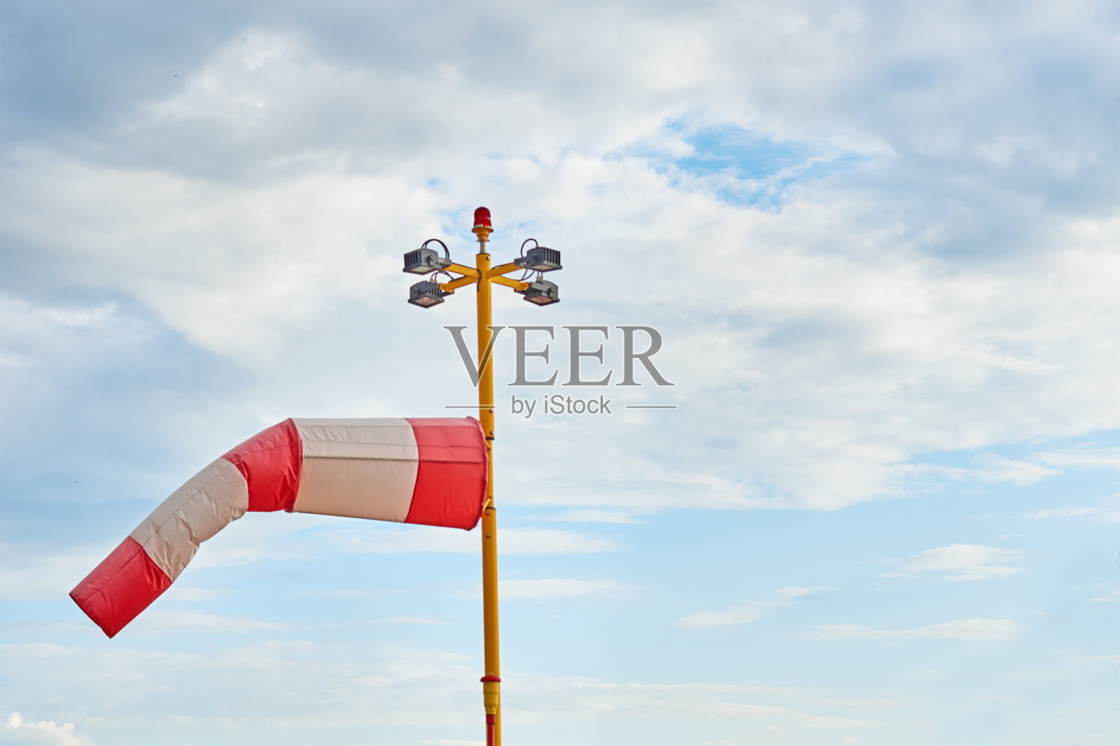 风向标。在多云的天空中吹着风的指示器照片摄影图片