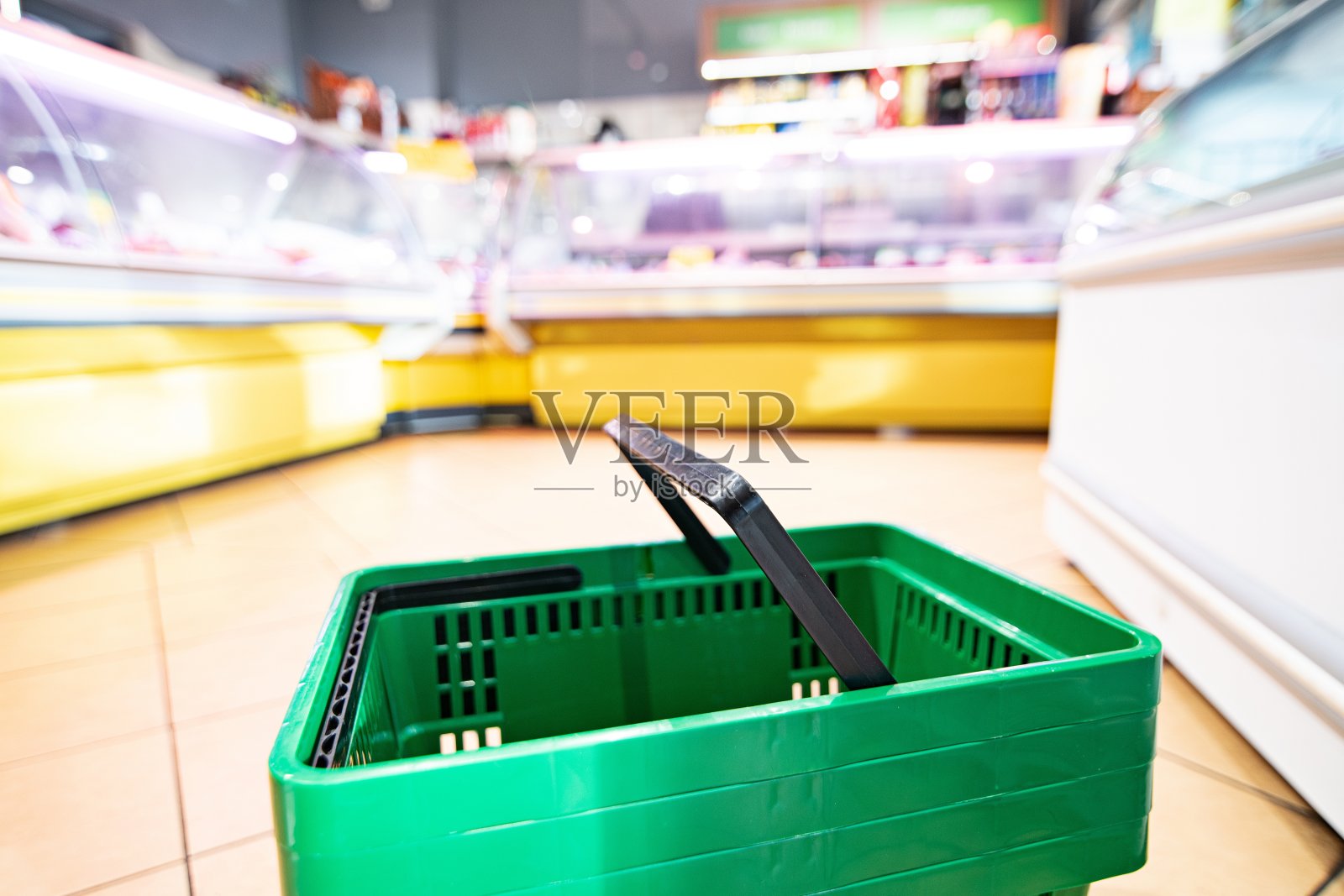 超市里的绿色塑料购物篮。照片摄影图片