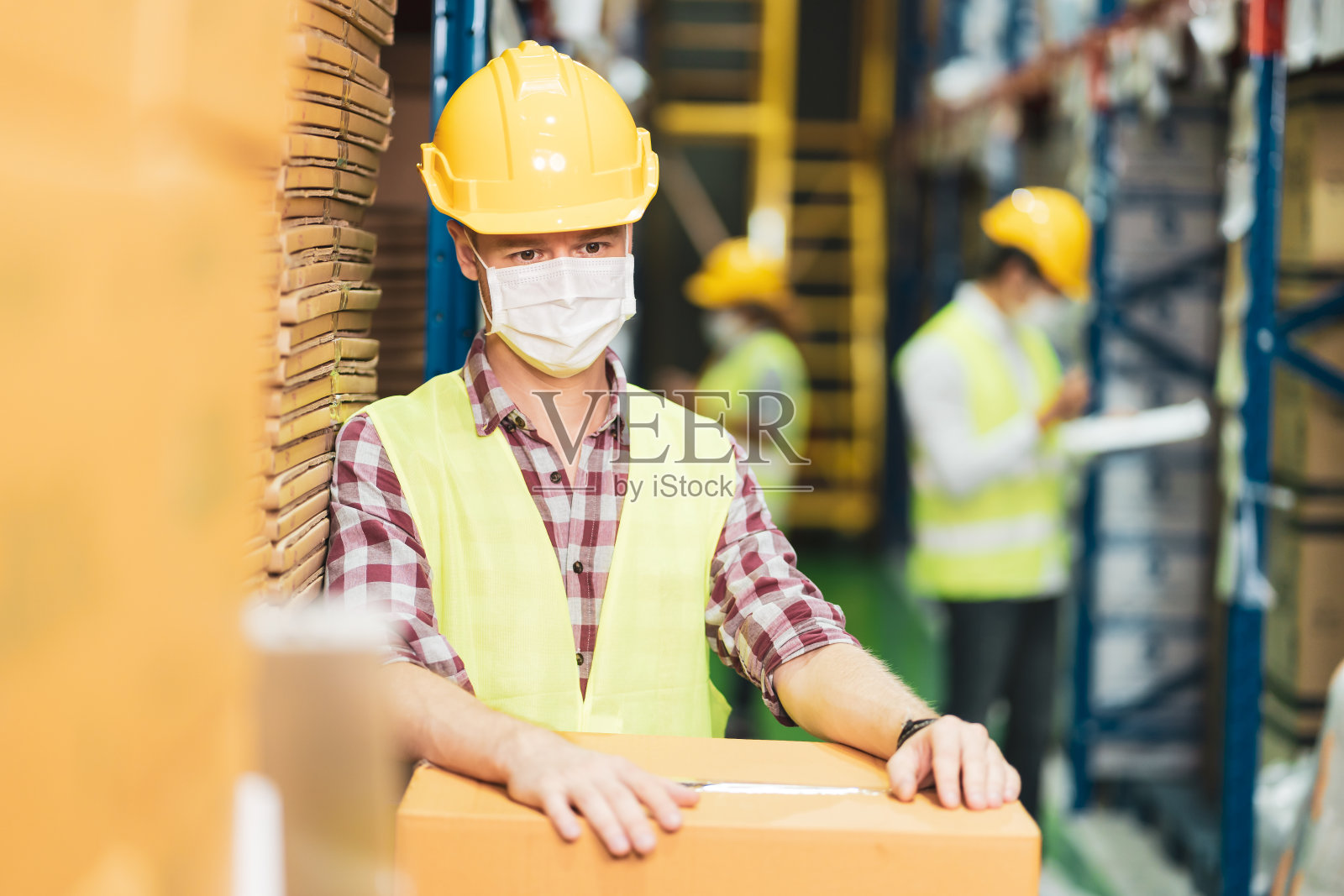 新型冠状病毒感染后，仓库工作人员戴口罩成为新常态照片摄影图片