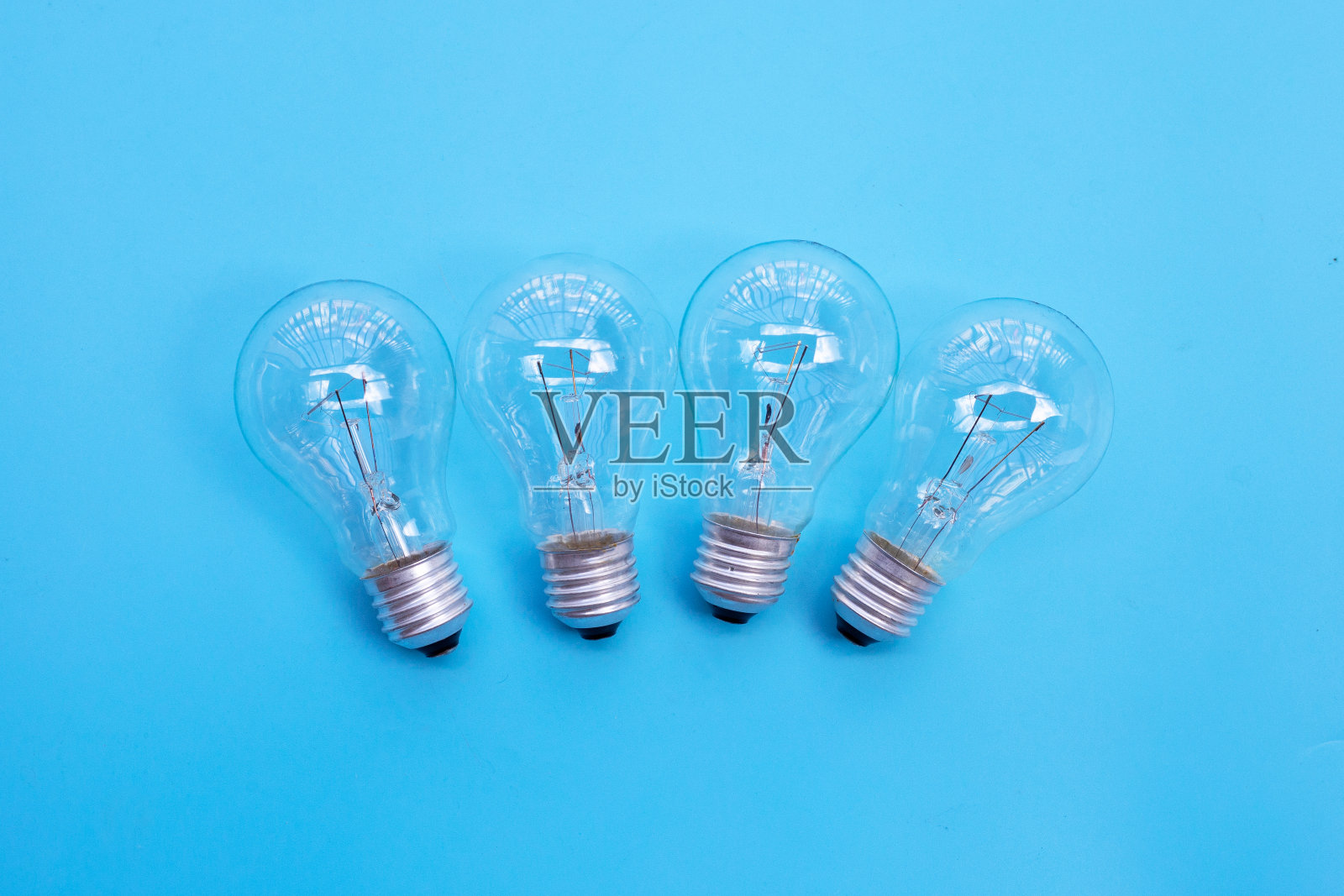 蓝色背景上的灯泡。思想和创造性思维的概念。俯视图照片摄影图片