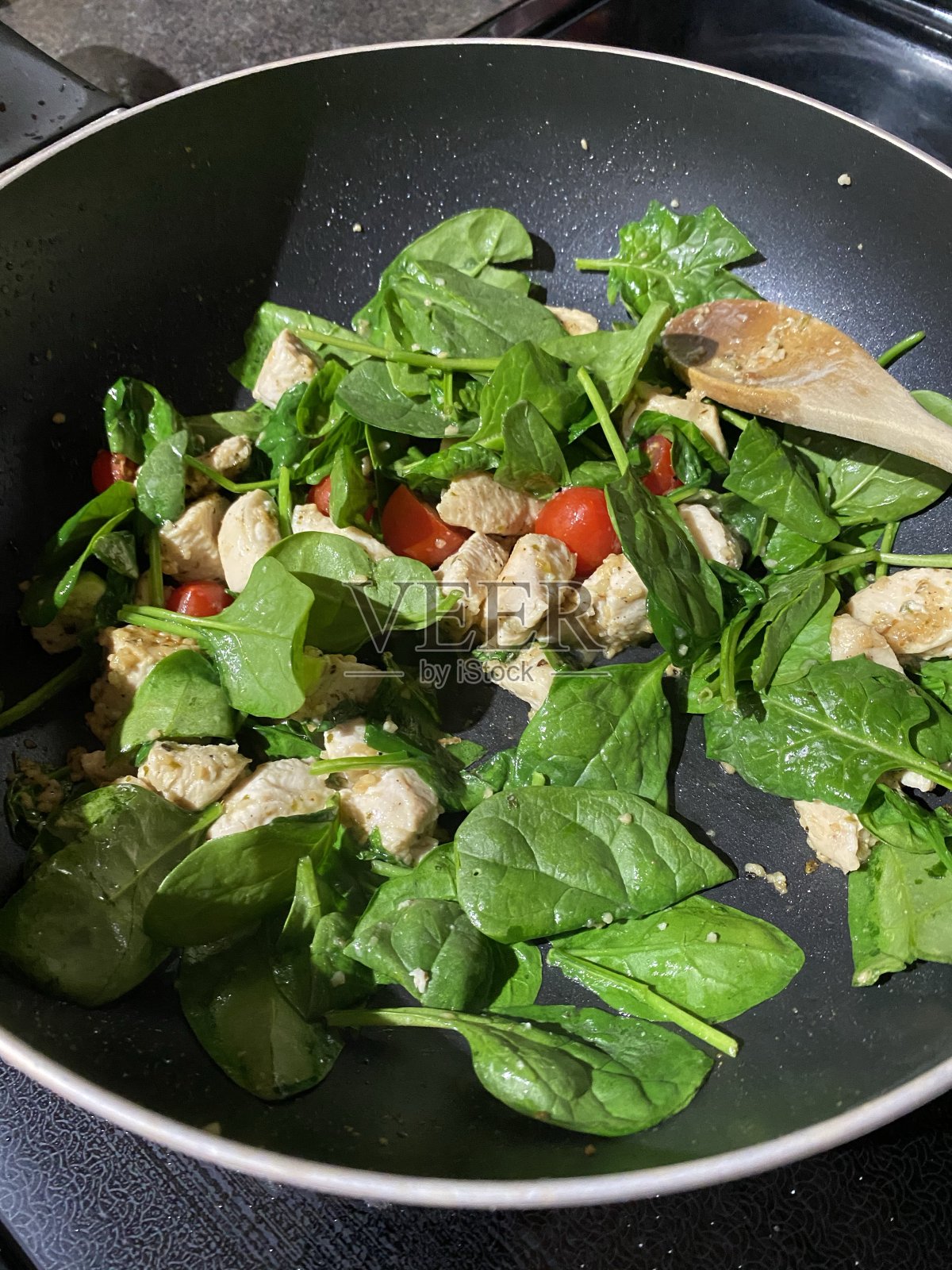 烹饪鸡肉，菠菜和番茄照片摄影图片