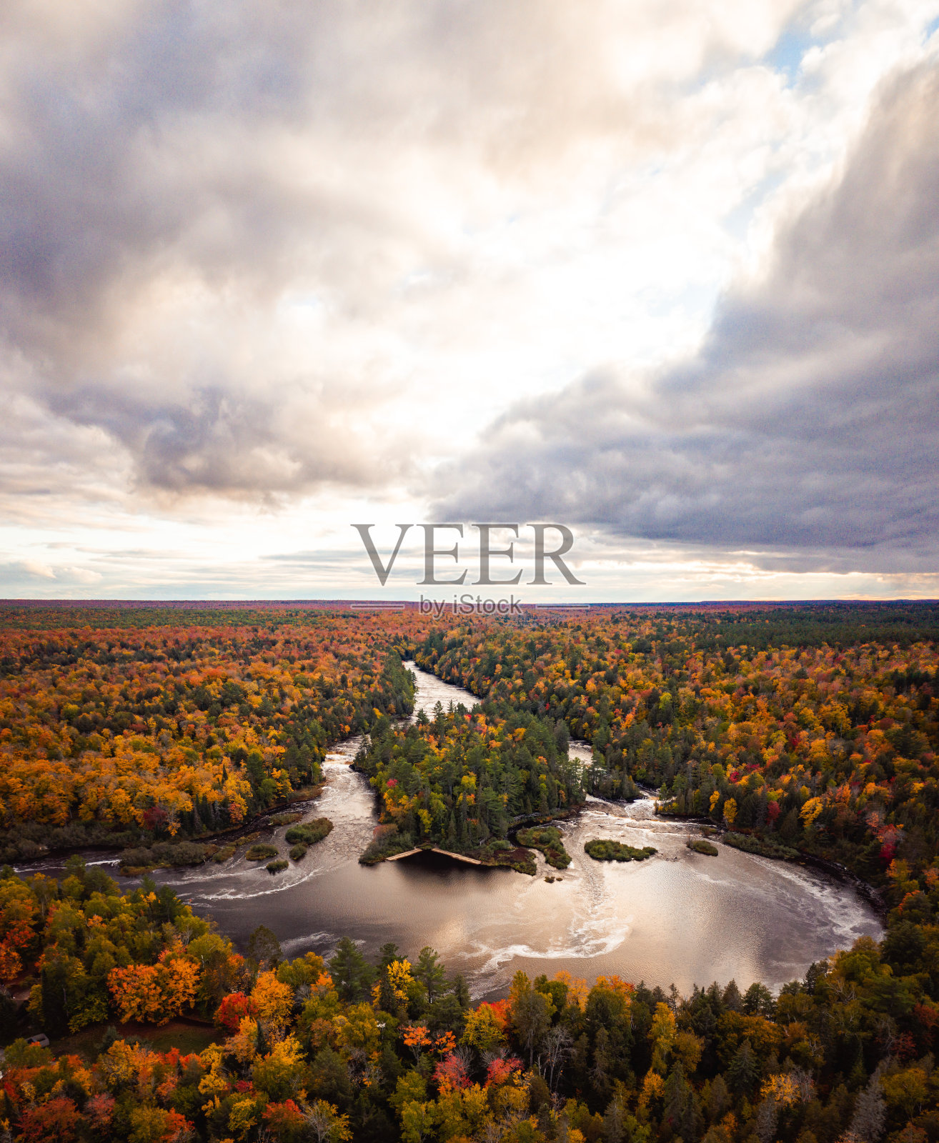 美丽的空中低处瀑布瀑布在塔夸梅农河被常绿和秋季树叶彩色落叶树包围黄色，绿色，红色和橙色的叶子在上密歇根。照片摄影图片