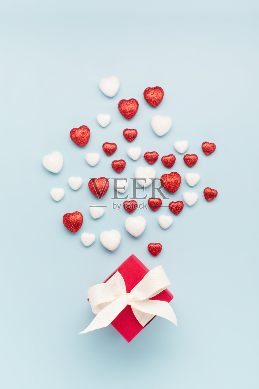 情人节贺卡。红白小闪亮的心，淡蓝背景上的礼盒。照片摄影图片