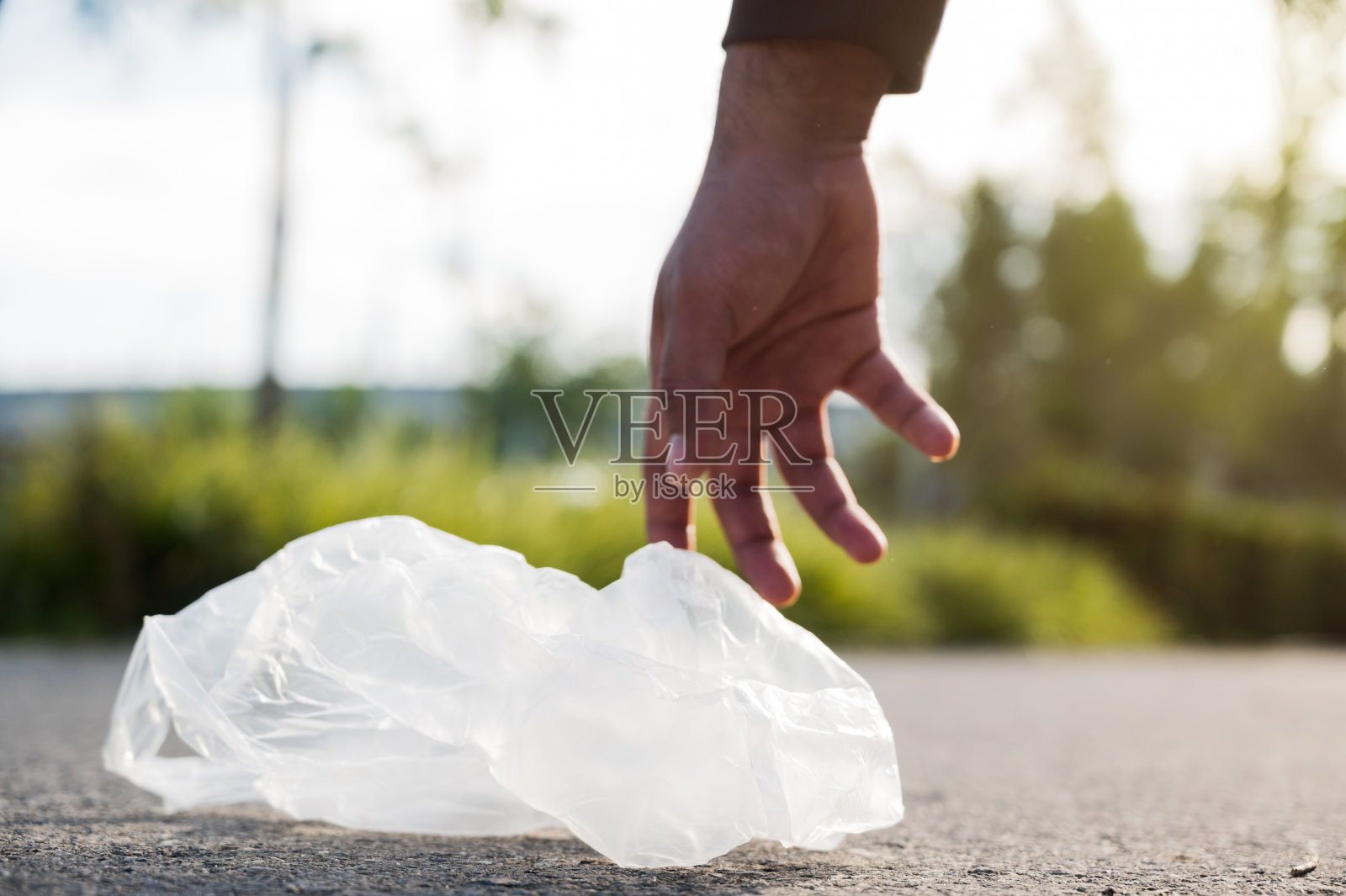 一名男子正在帮助收集街道上的塑料袋，以保持街道清洁和塑料垃圾分类。照片摄影图片