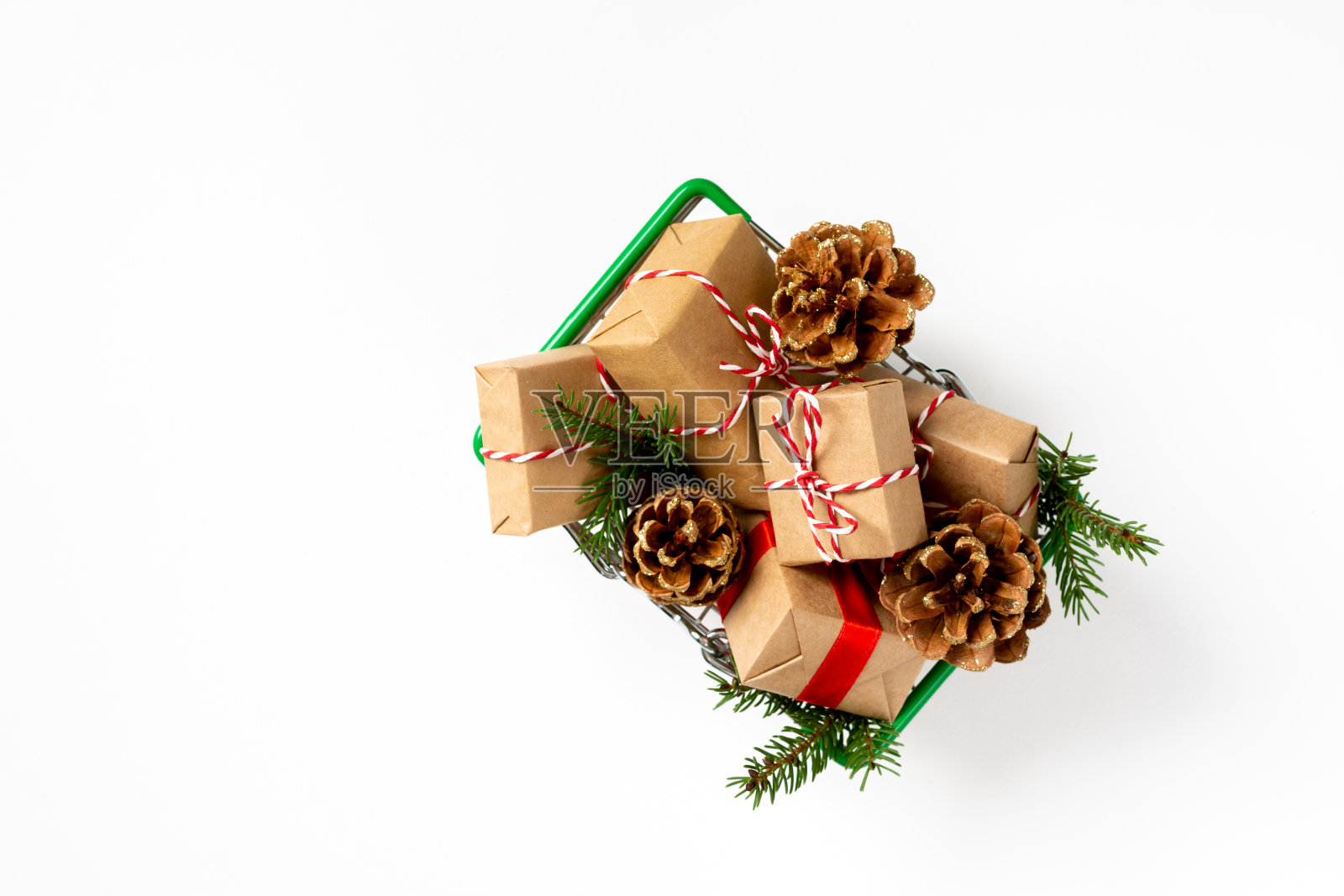 购物车里有很多圣诞和新年礼物盒，背景是白色的。购买圣诞礼物的概念。圣诞购物照片摄影图片