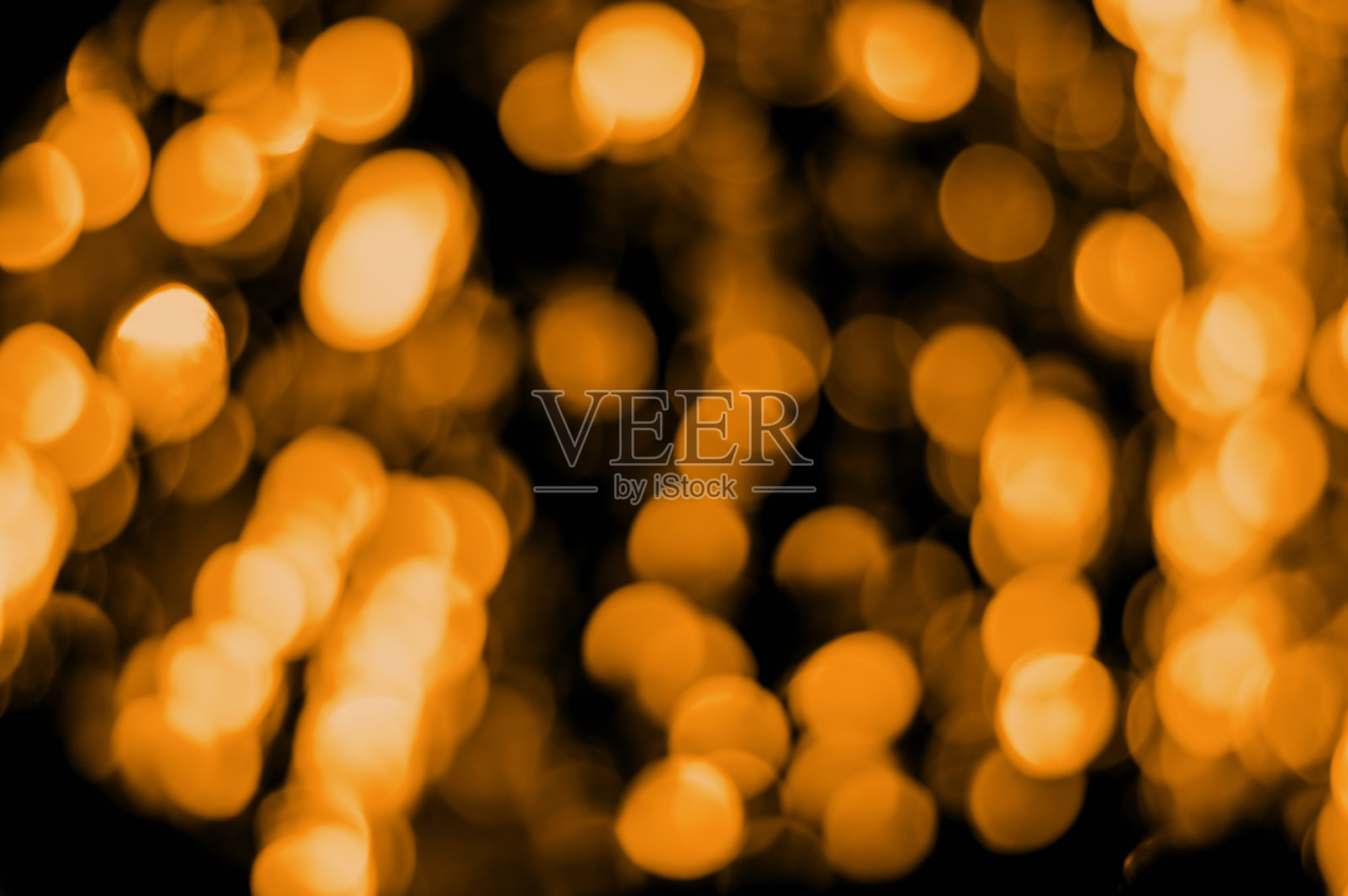 在黑色背景上散焦金色(亮黄色)散焦。抽象的背景。圣诞节散景照片摄影图片