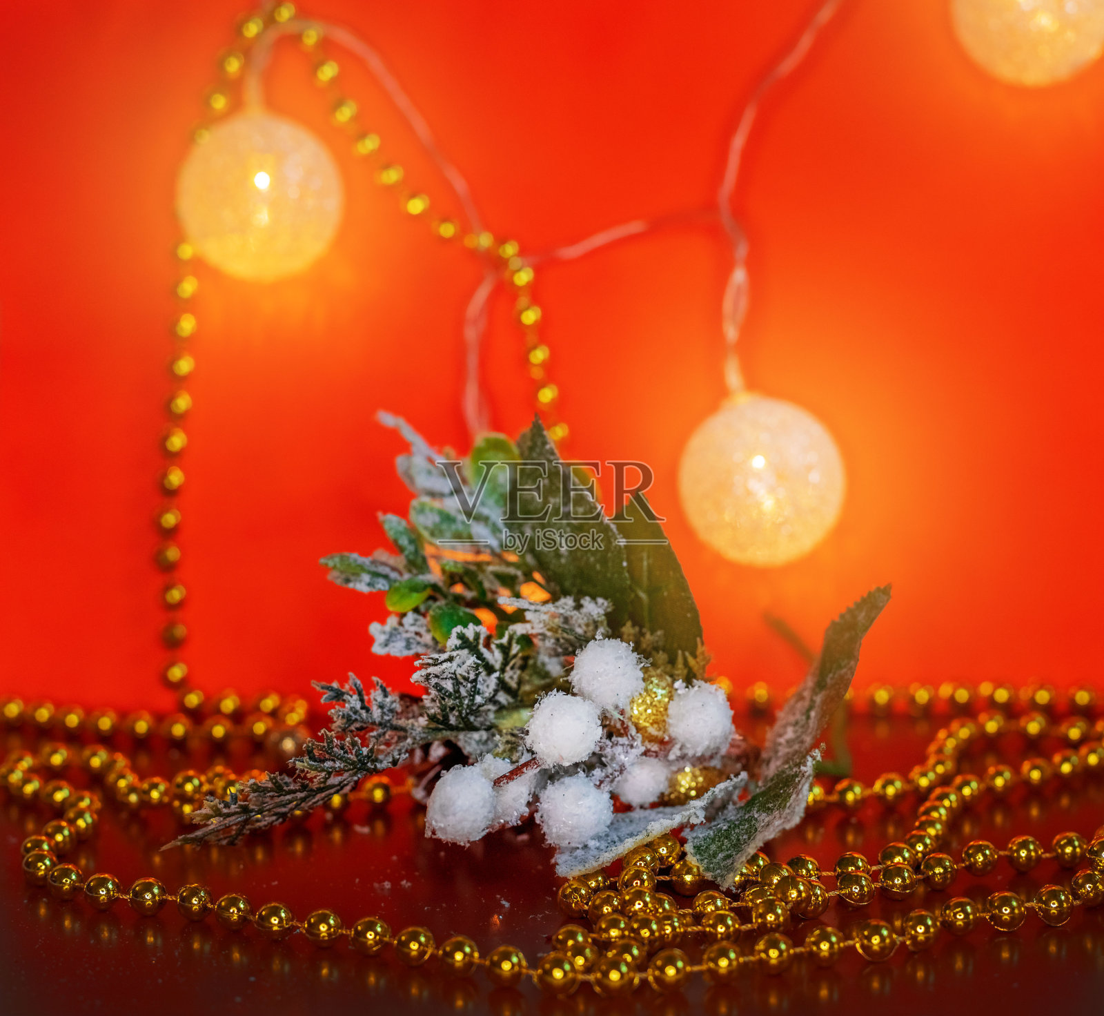 圣诞组成。红色背景上的圣诞花环、雪枝和金珠子。新2021年。副本的空间。照片摄影图片