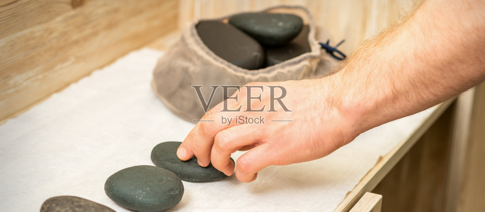 按摩师使用黑色按摩石照片摄影图片