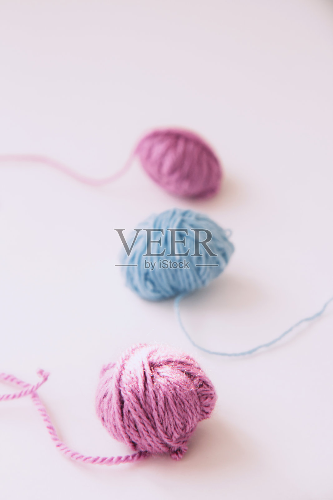 三股多色纱线在一个浅色的背景上照片摄影图片