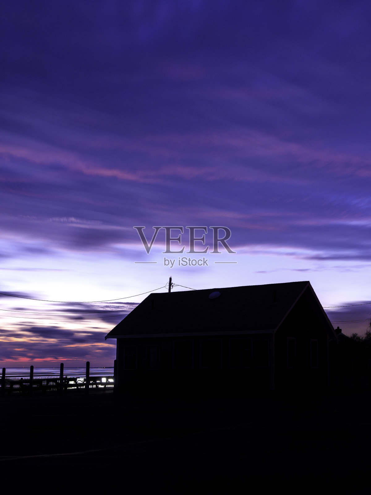 黄昏时海滩上的剪影小屋照片摄影图片