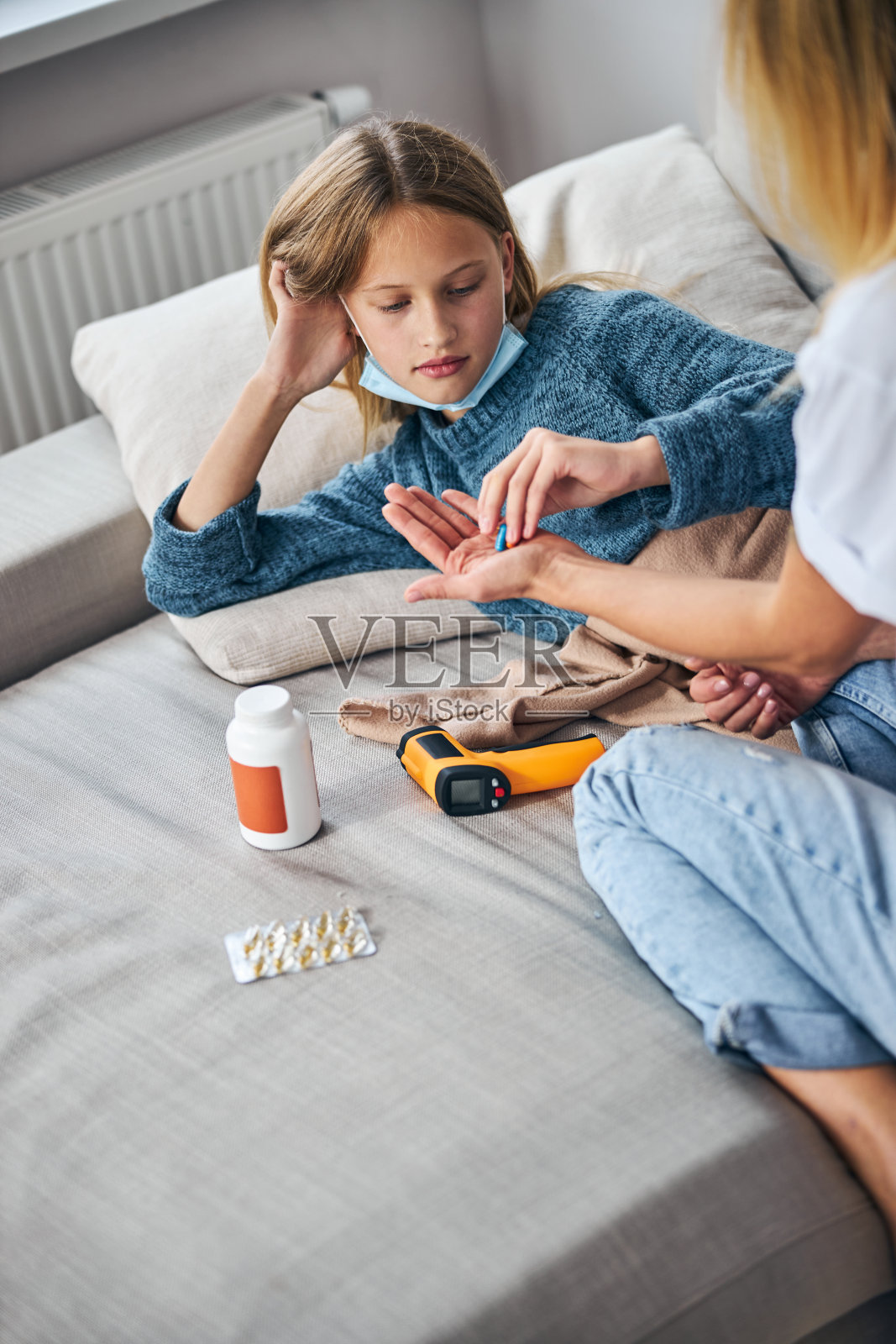 生病的孩子从她妈妈手里拿着药片照片摄影图片