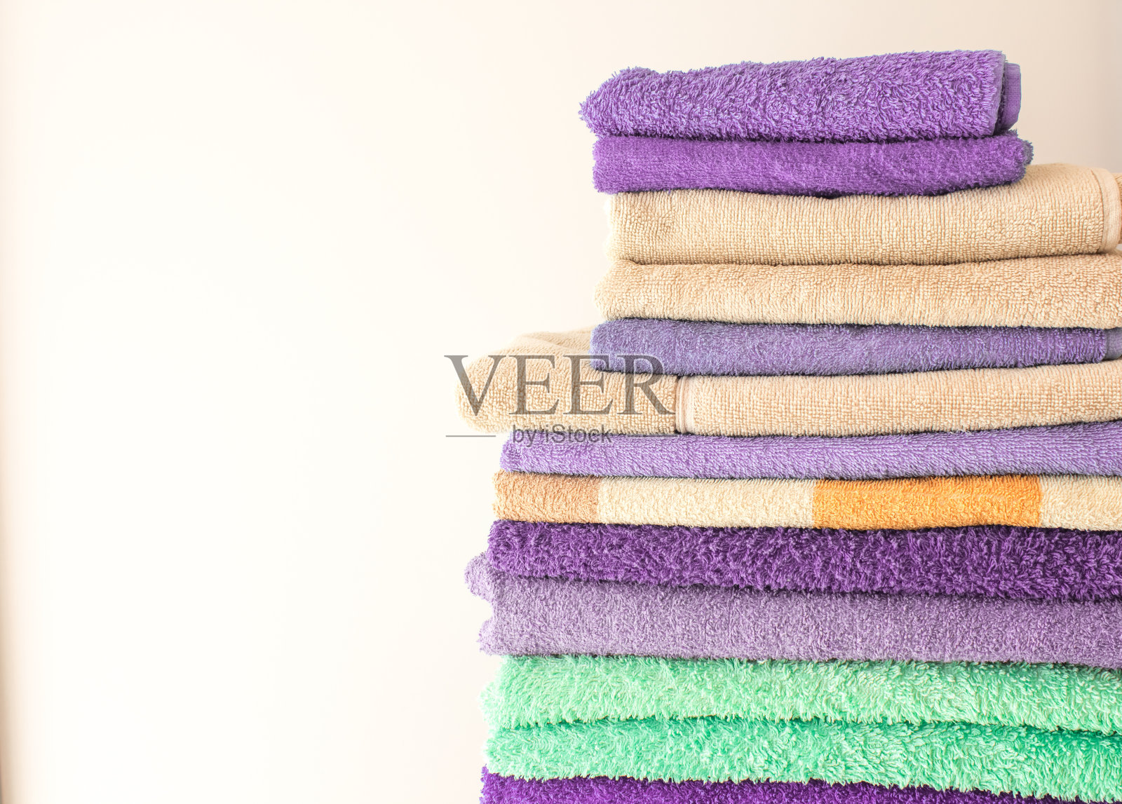 五颜六色的浴巾摞在一起。用于酒店、家庭、浴室、厨房的纯棉毛巾照片摄影图片