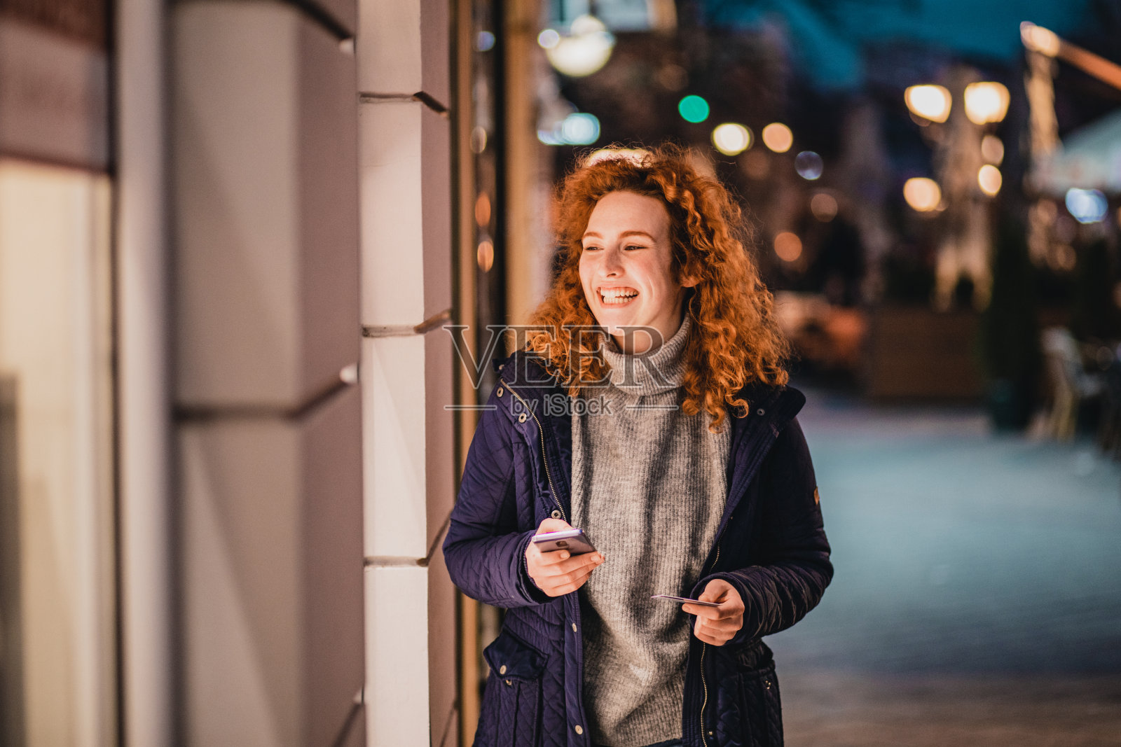 年轻女子在户外使用手机银行照片摄影图片