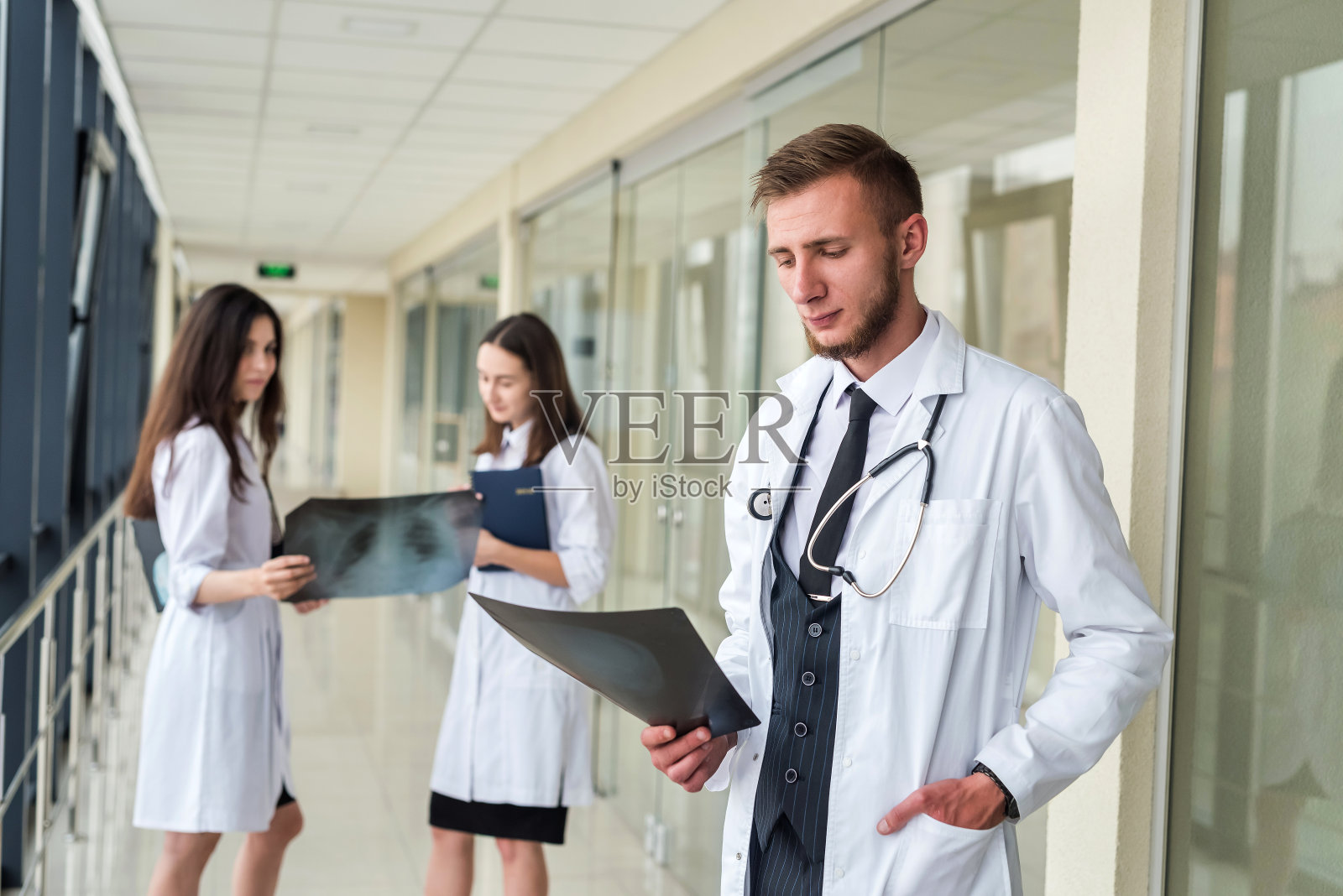 团队的年轻医生在治疗前看病人的胸部x光片检测出冠状病毒照片摄影图片