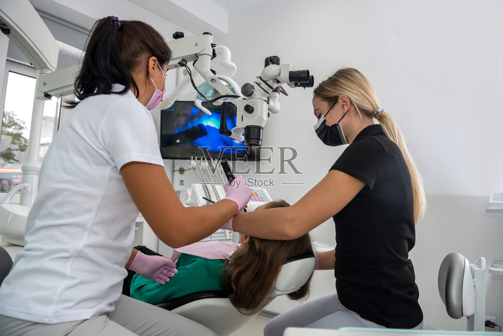 牙科医生在诊所使用紫外线灯为病人美白牙齿照片摄影图片