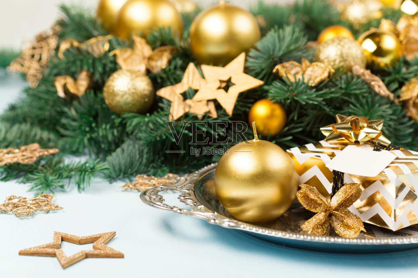 蓝色木质背景上有金色蜡烛的圣诞花环或花冠。照片摄影图片