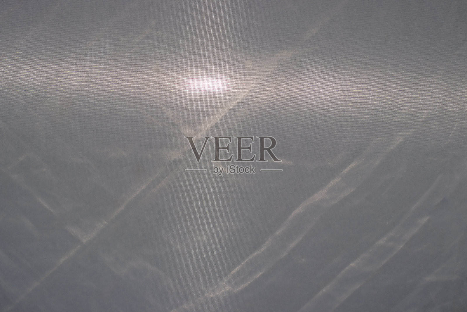 灰色织物纹理与手电筒光线，灰色背景。皱纹布照片摄影图片