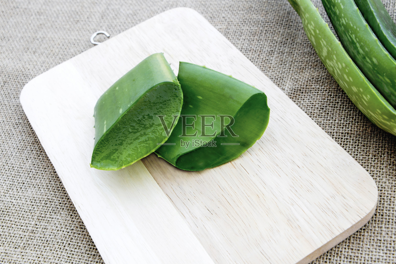 芦荟鲜片在木材背景上，它是成分化妆品美容产品或食品保健和医药作为皮肤护理治疗的理念。照片摄影图片