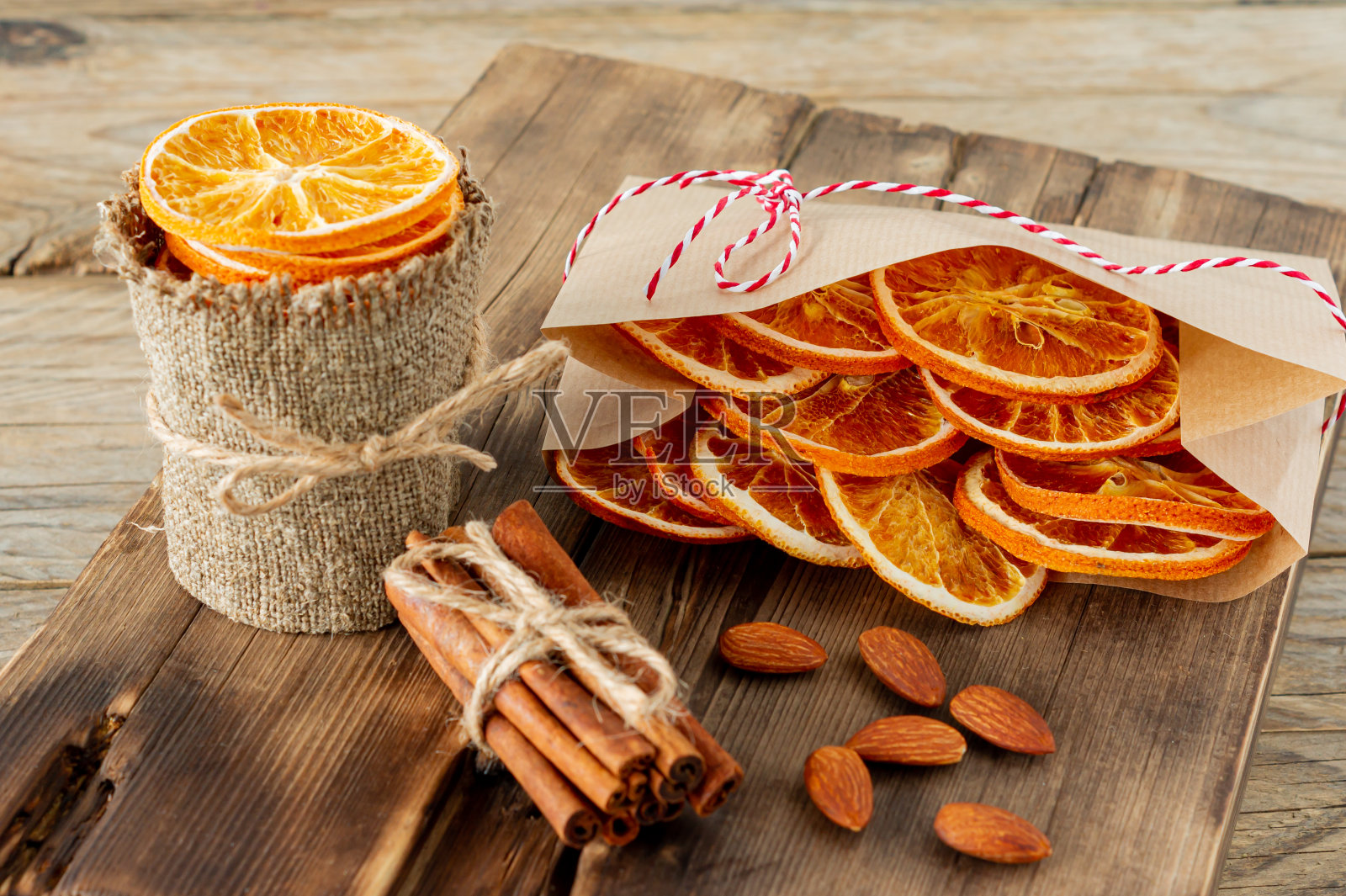 圣诞组成。木质背景上摆放着干橙子、肉桂和杏仁。乡村，节日香料配料。照片摄影图片