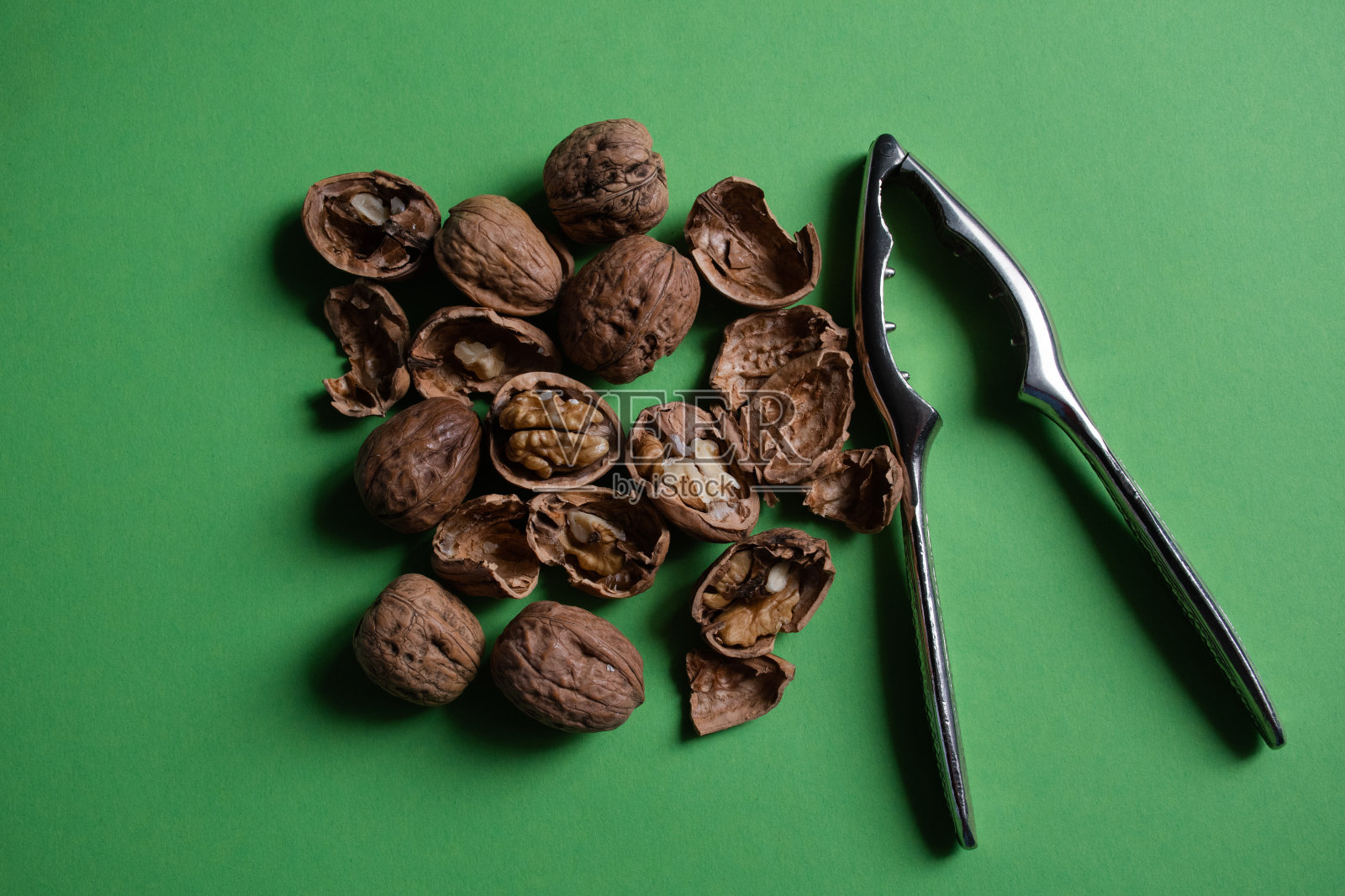 胡桃，贝壳和银胡桃夹在绿色的背景照片摄影图片