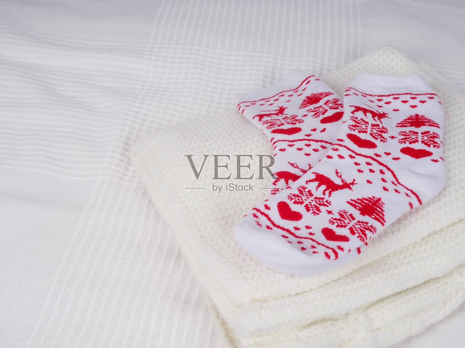 红色的圣诞袜躺在白色的床上等待着新的一年，空间为设计，有选择的重点照片摄影图片