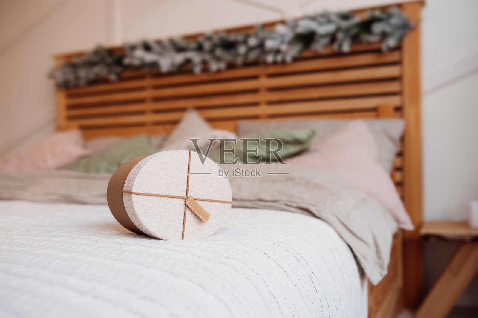 椭圆形环保工艺礼品盒装饰圆锥形和冷杉枝在舒适的床上枕头，选择性的焦点照片摄影图片