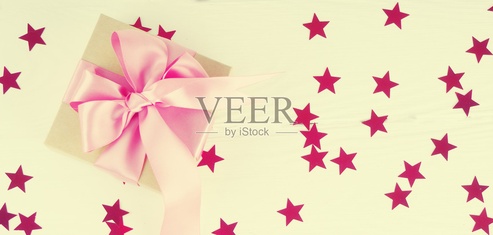 横幅为网络礼盒与明亮的红粉色丝带在白色背景与星星。文字到明信片的空间照片摄影图片