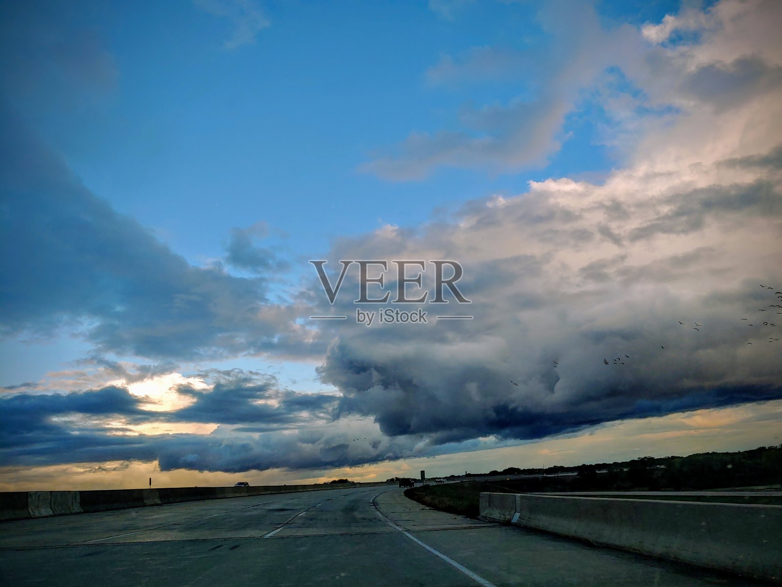 充满生气的多云天空在三车道高速公路上照片摄影图片