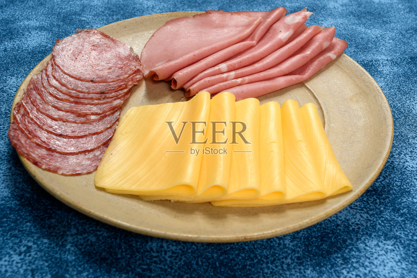 用切片的“u200b”u200bsalami bologna和牧场奶酪隔离在蓝色背景照片摄影图片