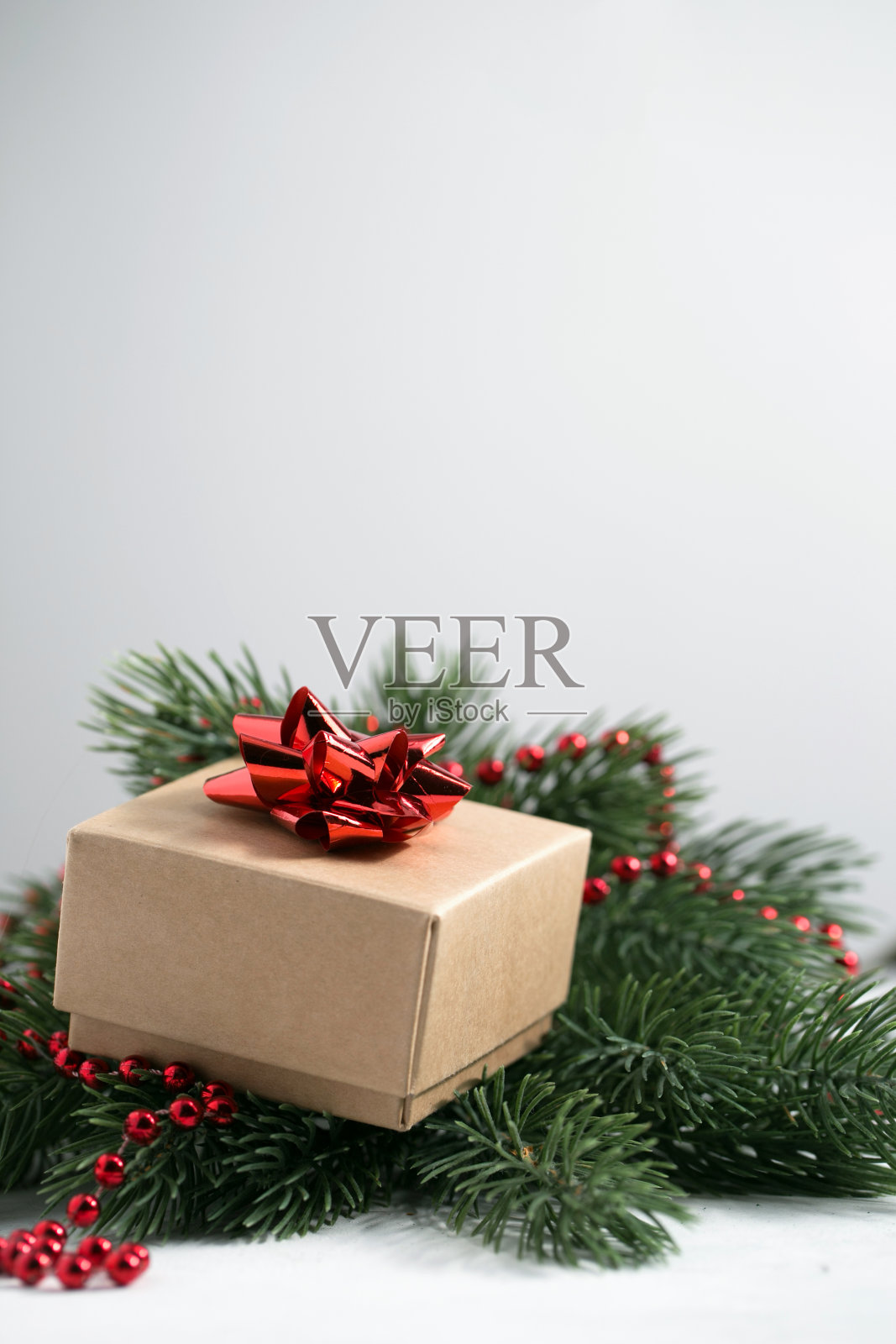 圣诞礼物挂在松树树枝上红蝴蝶结照片摄影图片