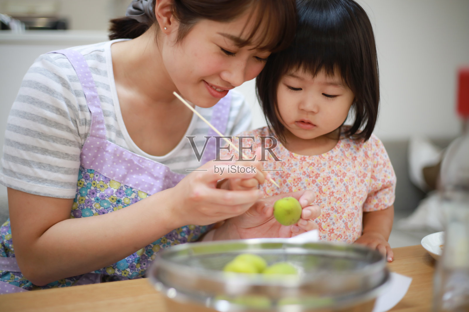 父母和孩子酿梅子酒照片摄影图片