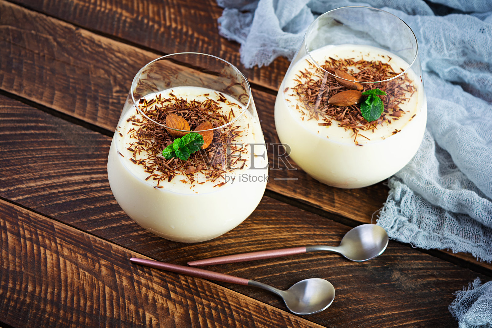 甜牛奶布丁，杏仁和巧克力片，木质背景照片摄影图片