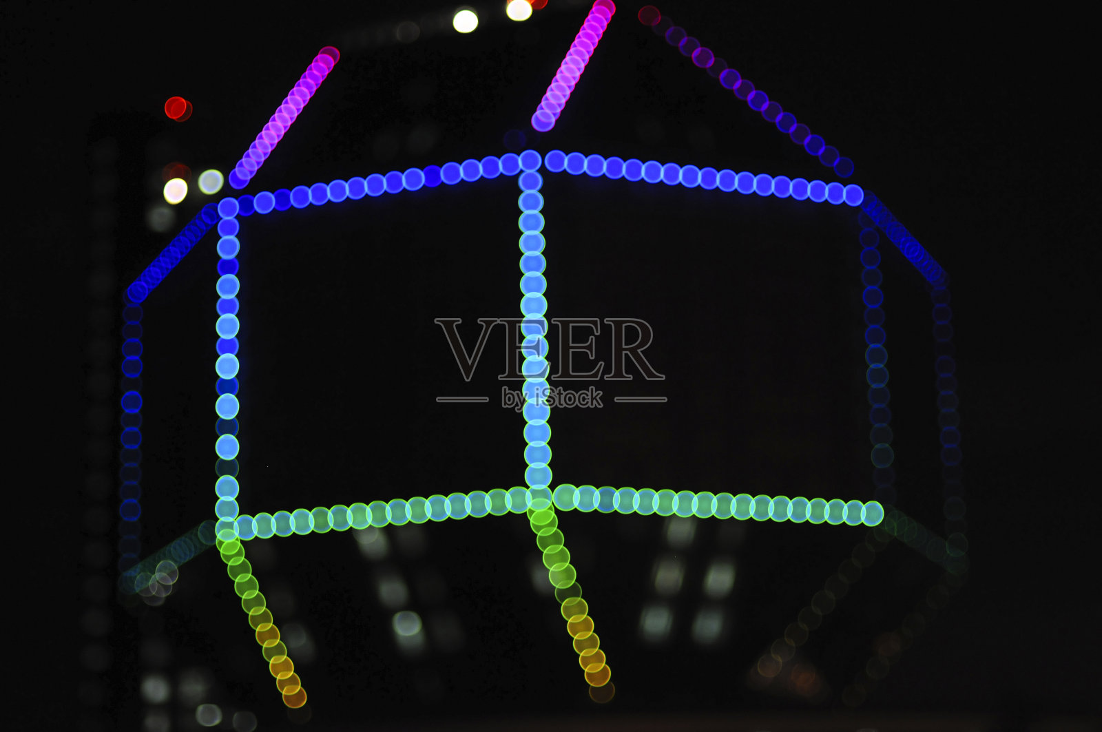 模糊的夜晚多色发光灯在黑色的背景。新年和圣诞节的概念照片摄影图片