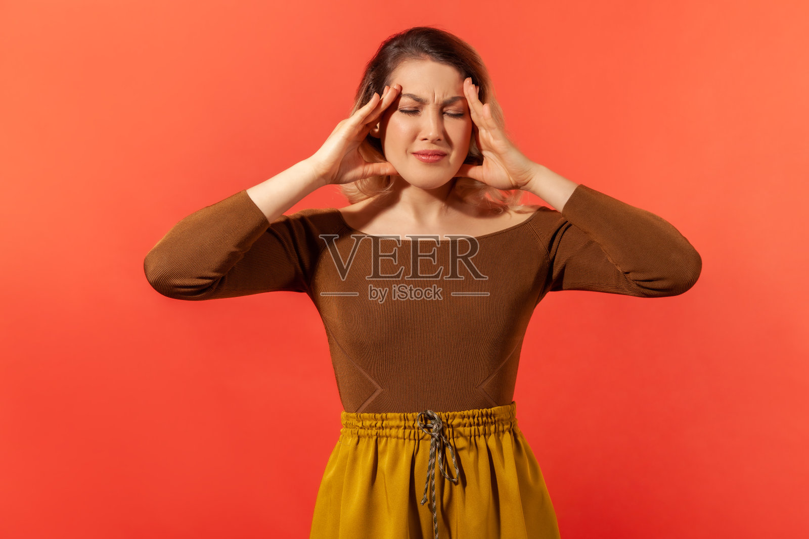 年轻女子抱着头，感到头痛照片摄影图片