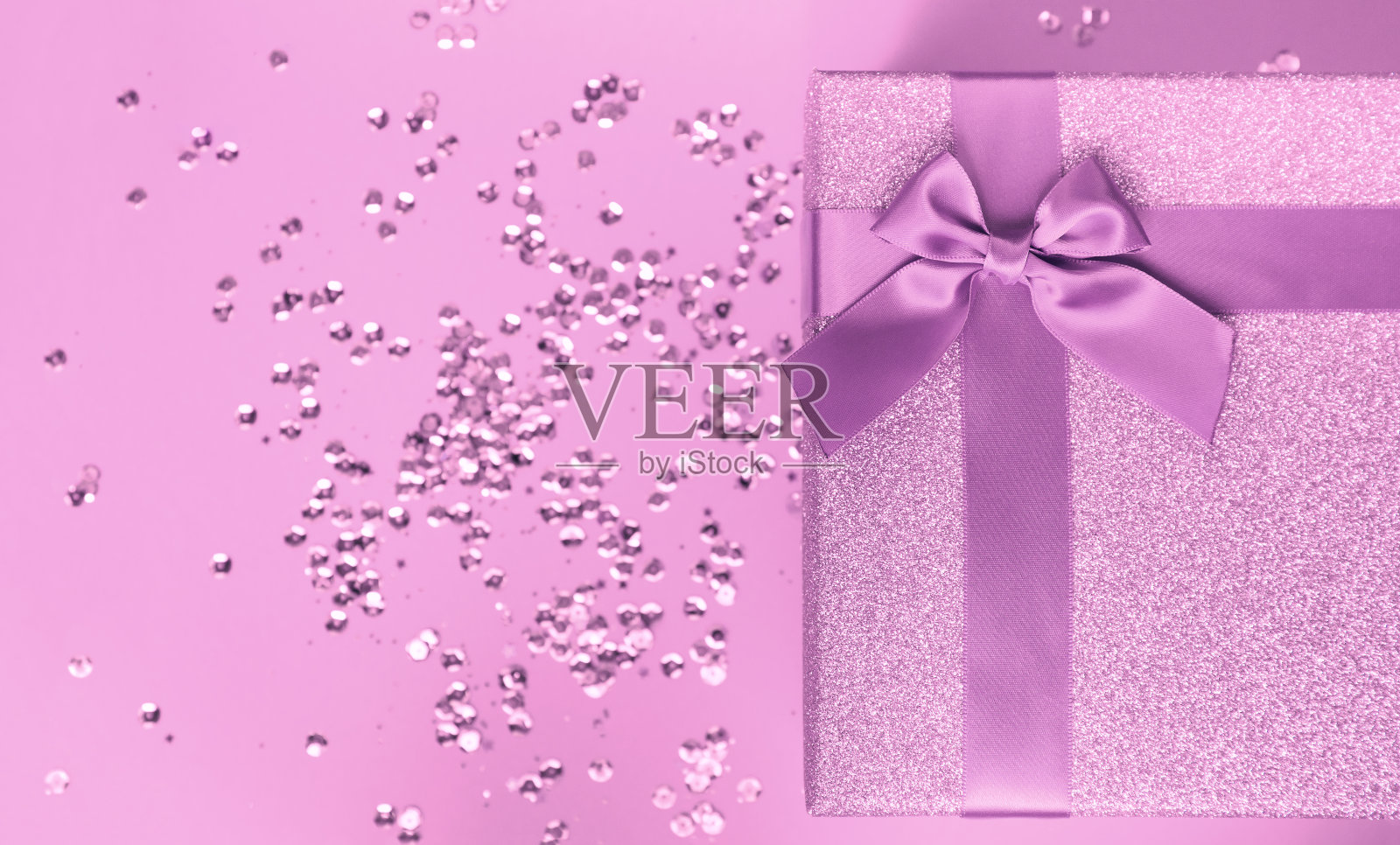 大礼品盒与蝴蝶结上彩色背景与亮片。圣诞节或生日礼物。照片摄影图片