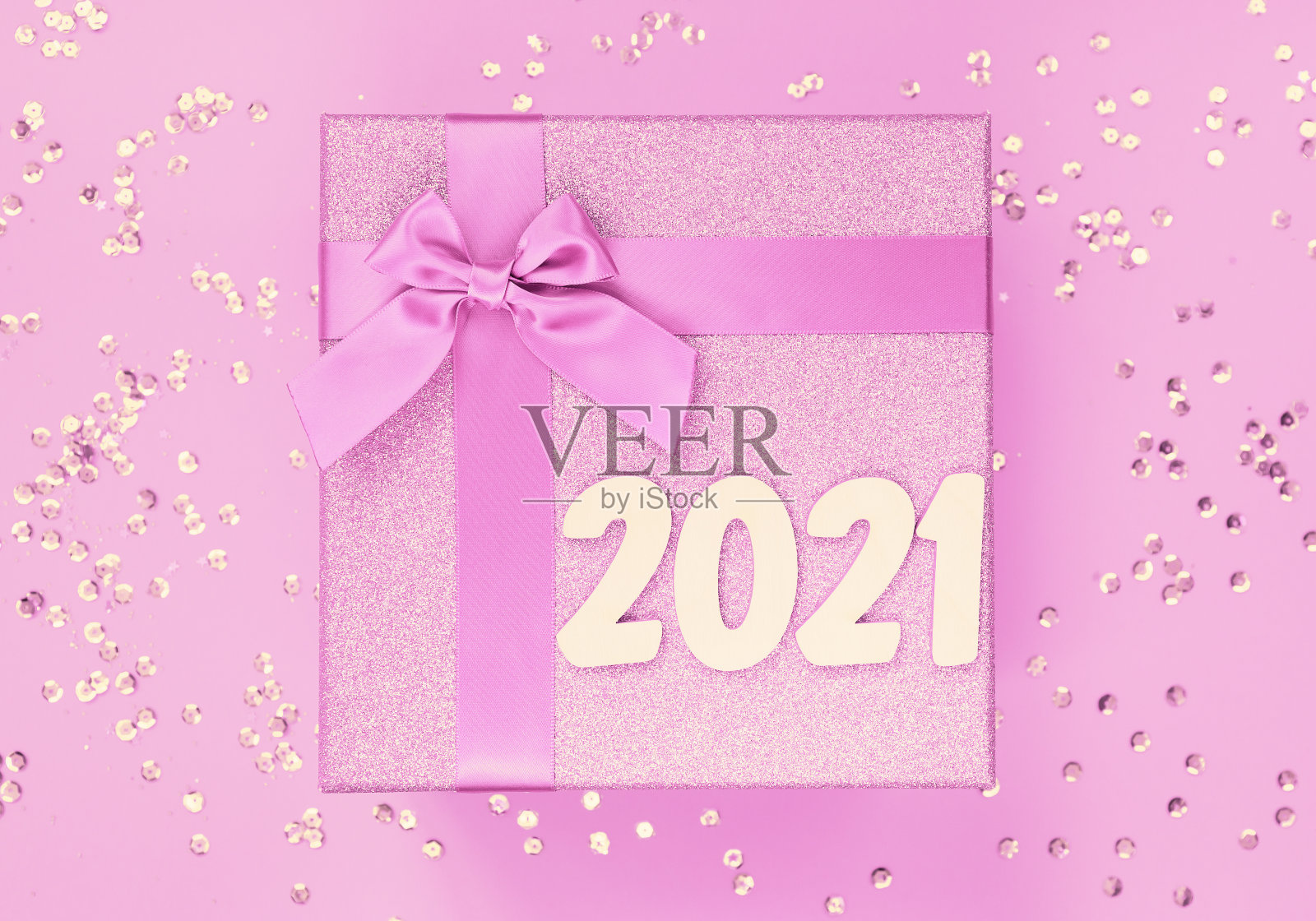 大礼品盒与蝴蝶结上彩色背景与亮片。圣诞礼物。照片摄影图片