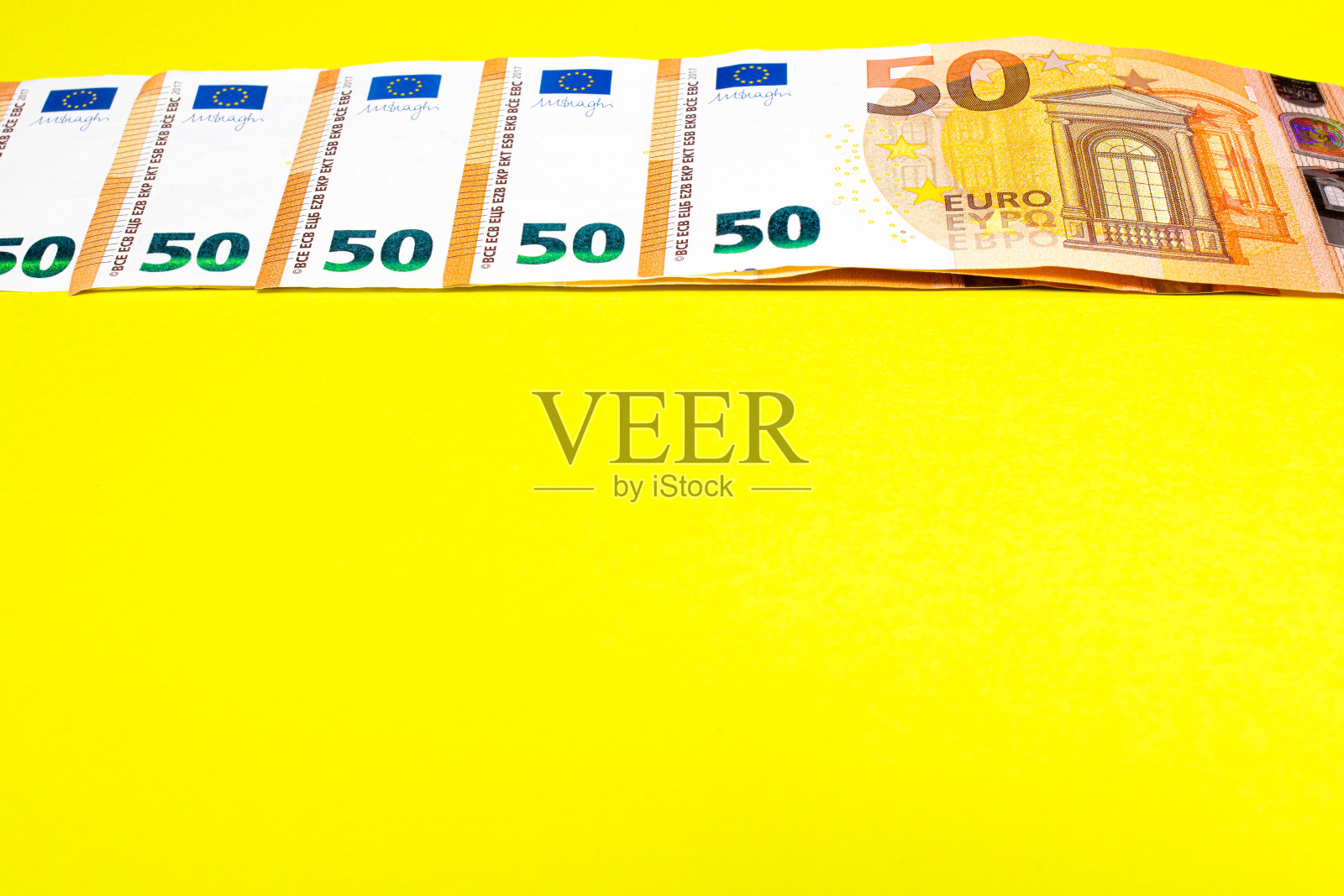 黄色背景的50欧元纸币碎片。关闭货币货币。文本复制空间照片摄影图片