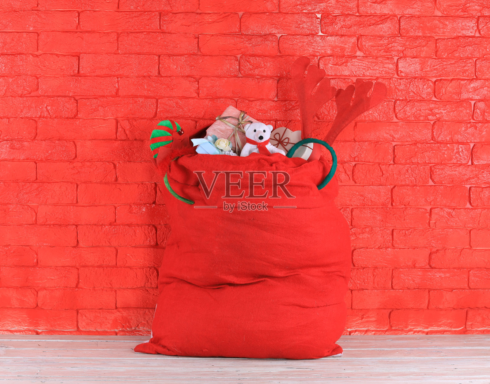 圣诞包里装着礼物，红砖砌墙照片摄影图片