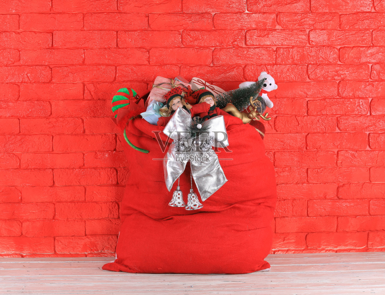 圣诞包里装着礼物，红砖砌墙照片摄影图片