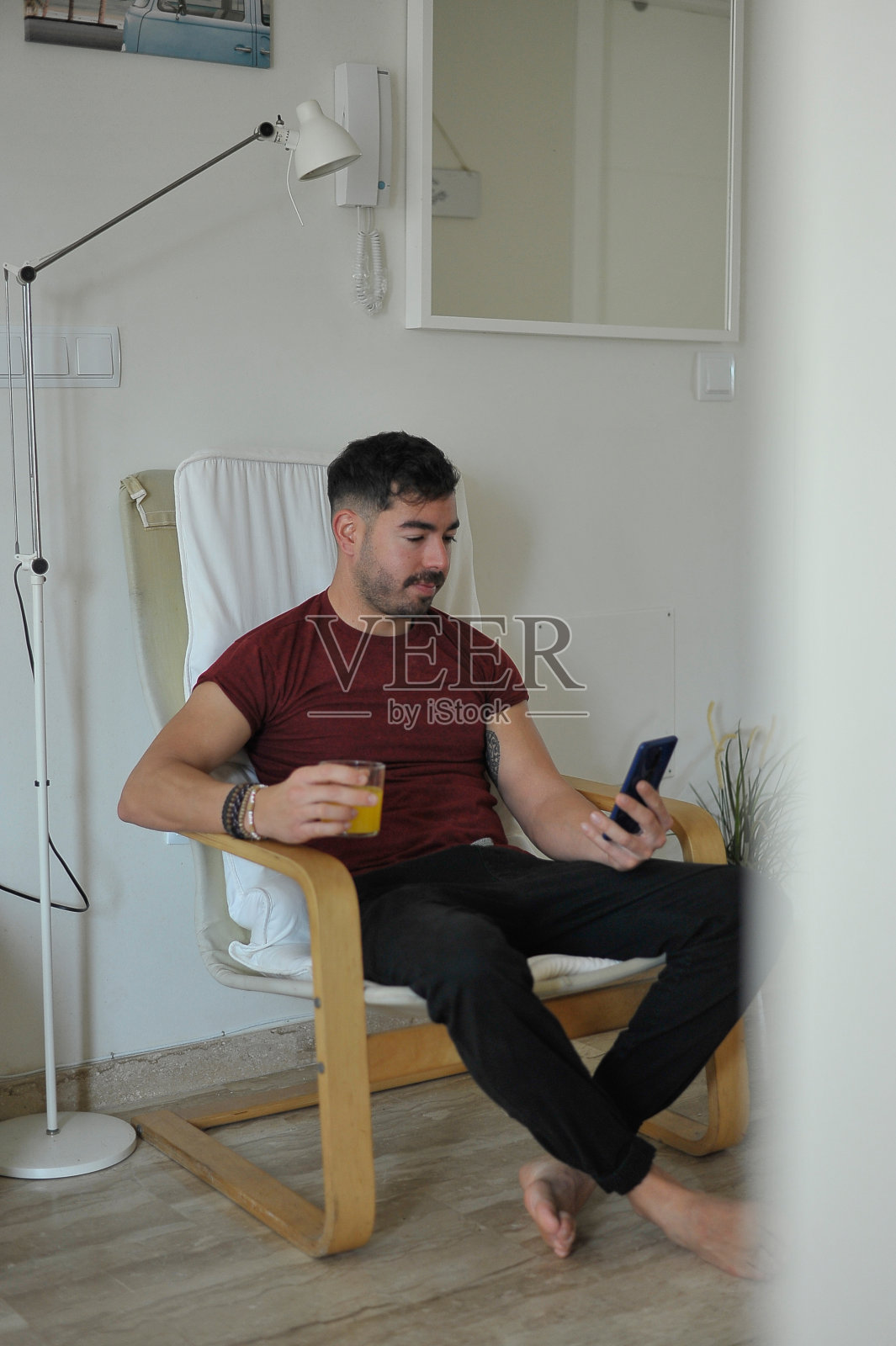 一个男人在家里用手机放松照片摄影图片