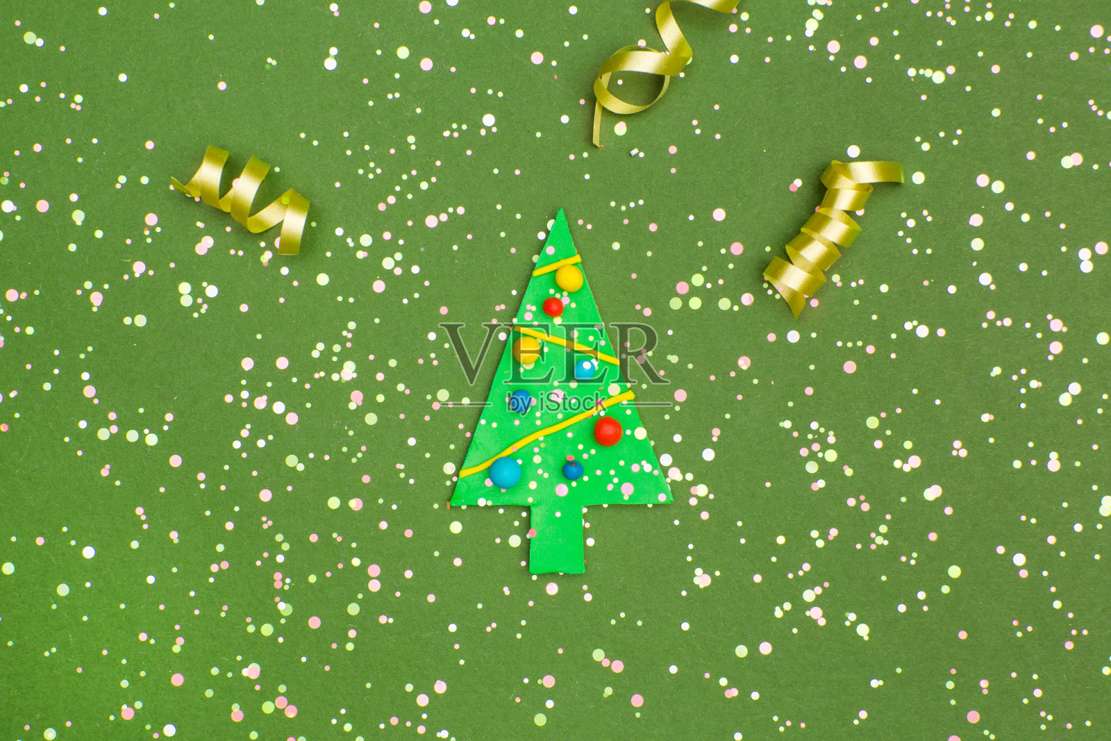 装饰圣诞树，丝带和五彩纸屑在绿色的背景照片摄影图片